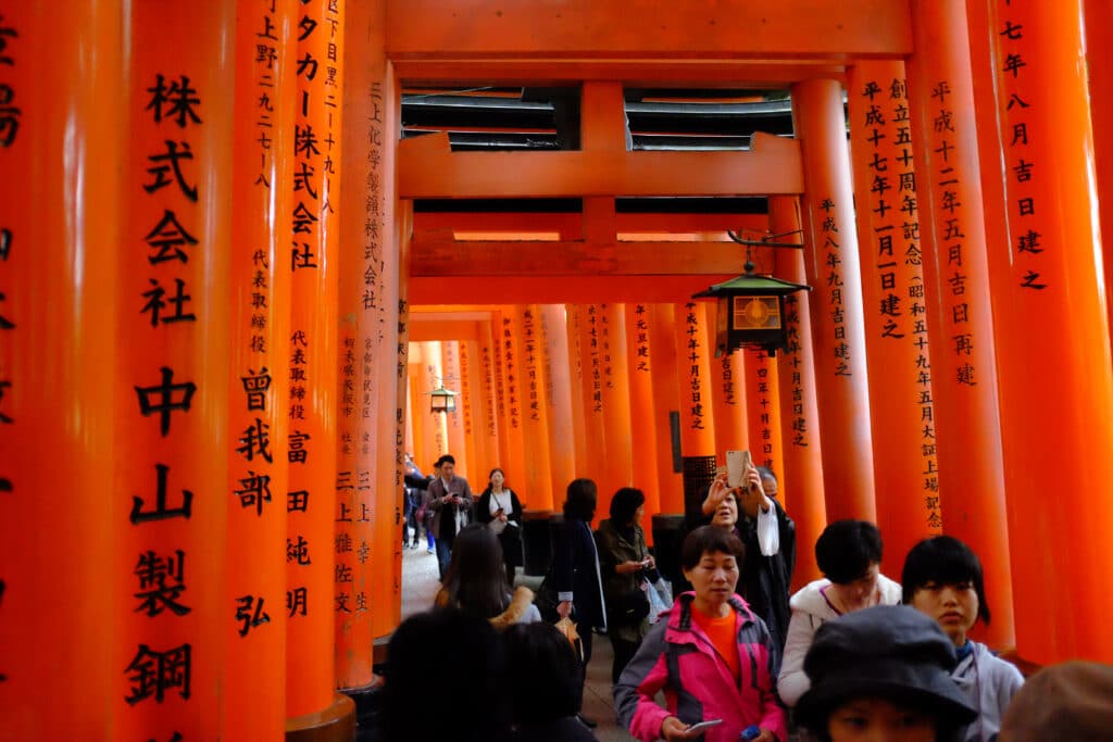 Visitors walking through the torii gates at Fushimi Inari Shrine in Kyoto