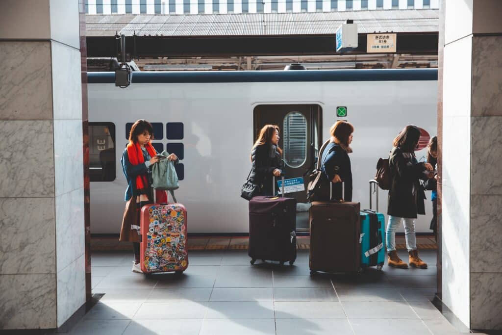 Travelers with luggage at a busy train station in Japan