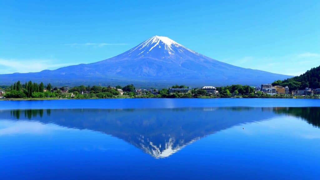 Mount Fuji reflected in the calm blue waters of Lake Kawaguchiko