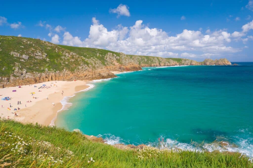 Porthcurno Beach with turquoise water and cliffs in Cornwall