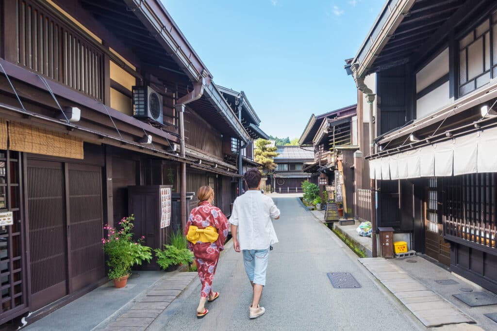 Couple walking through a traditional wooden street in Takayama's historic old town