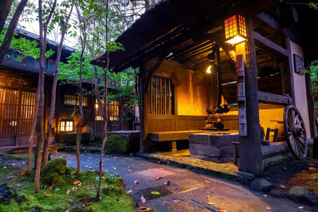 Traditional Japanese inn courtyard illuminated by warm lanterns in the evening