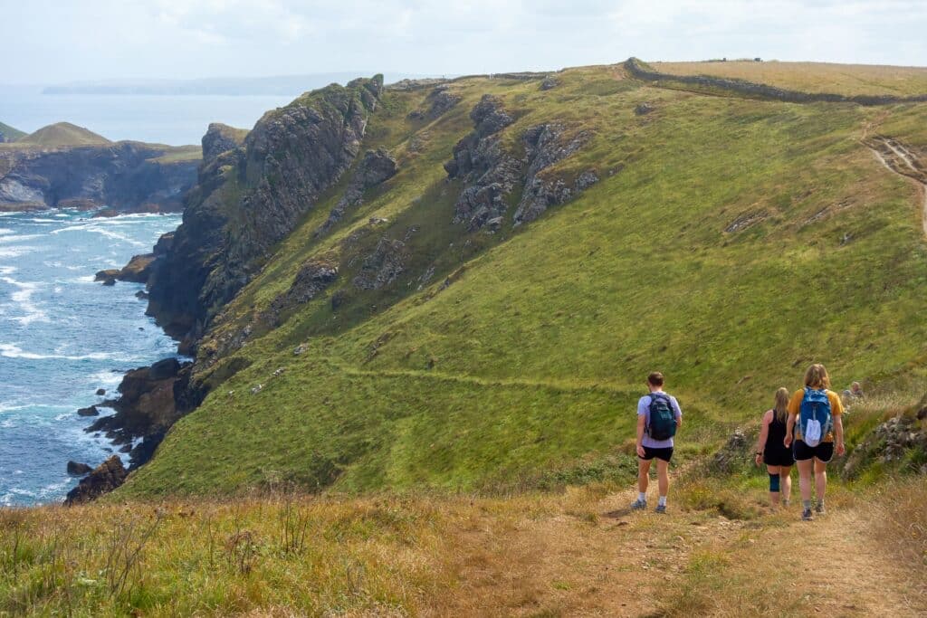 Hikers walking along the dramatic Cornwall coast