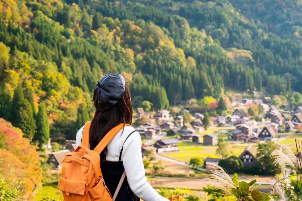 Traveler overlooking a traditional mountain village in Japan