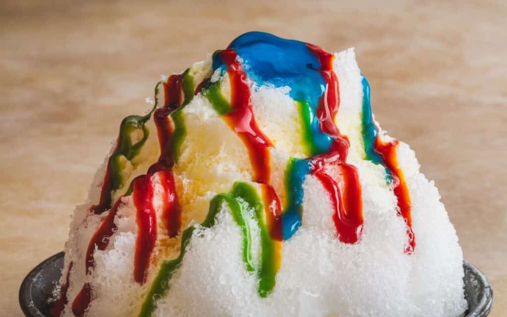 Japanese kakigori shaved ice dessert topped with colorful flavored syrups
