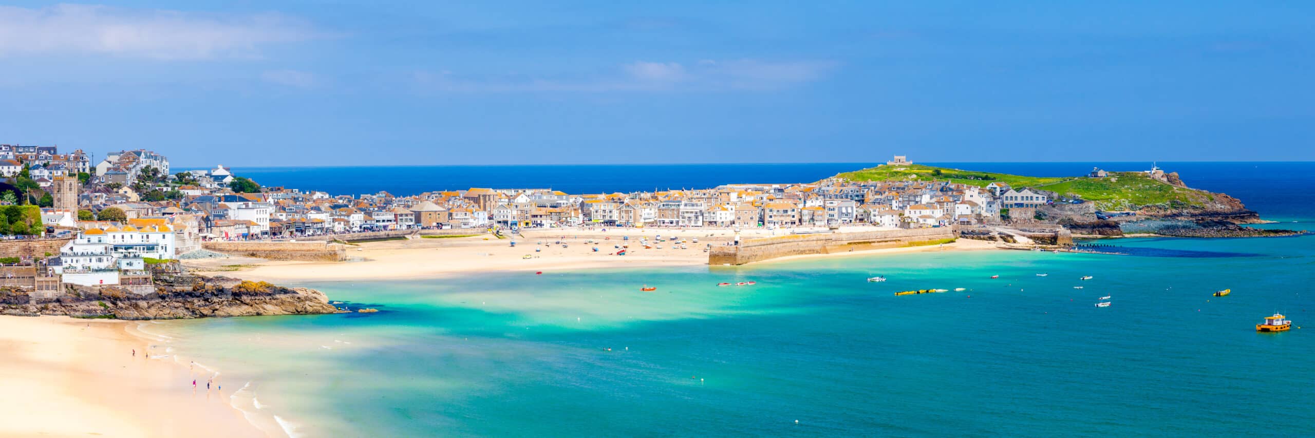 Panoramic view of St Ives Harbour in Cornwall, with sandy beaches, turquoise water and historic waterfront buildings